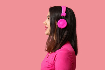 Wall Mural - Beautiful young woman in modern headphones on pink background