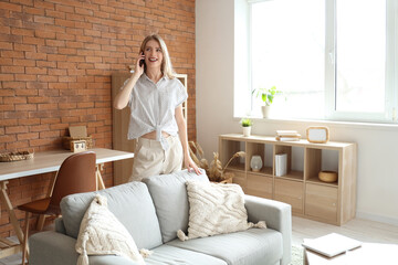 Sticker - Young pretty woman talking with mobile phone in living room