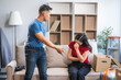 Young Asian couple managing a relocation amidst quarrels and disagreements. Proficient in handling moving logistics, cardboard boxes, and resolving disputes for a smoother transition.