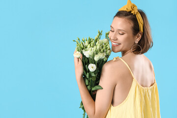 Poster - Young woman with eustoma flowers on blue background