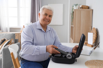 Sticker - Mature businessman with percussive massager on table in office