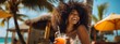 African American woman drinking a summer cocktail on the beach