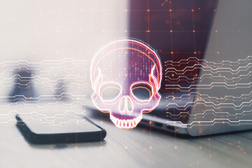 Wall Mural - Close up of laptop and smartphone on desk with creative skull and circuit hologram on blurry background. Malware and ransomware concept. Double exposure.