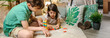 Banner of happy children playing together with stacking piece game in front of homemade tent on living room. Brother and sister having fun and enjoying in camping at home. Staycation concept.