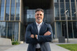 © Stock 4 You - Proud portrait of older senior businessman professional ceo, manager, leader looking camera near city office. Smiling confident 40s latin hispanic mature business man standing crossed arms, copy space