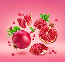 Wall Mural - Pomegranate fruits and pomegranate seeds levitating in air on pink background. File contains clipping paths.