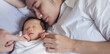 Close up portrait of beautiful young asian caucasian mother day girl kissing healthy newborn baby sleep in bed with copy space. Healthcare and medical love asia woman lifestyle mother's day banner