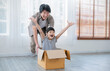 Asian single dad family father daughter girl packing cardboard box moving, online marketing e-commerce unpacking stuff belongings home delivery. Lifestyle happy white family together relocation
