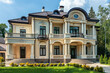 Elegant luxury mansion with lush greenery on sunny day