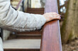 woman holding onto wooden railing while climbing stairs
