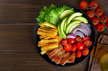 Canvas Print - Grilled sliced pork steak with potatoes, tomatoes and avocados