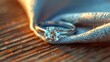 Sparkling diamond ring on a wooden table next to a fiber napkin. The concept of proper jewelry care