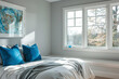 Gazing from a window seat in a bedroom with minimal gray walls and blue decor.