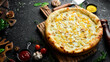 Classic pizza with chicken, pineapple and cheese. Cheese pizza. On a black stone background. Top view.