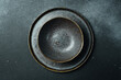 Empty gray plate (ceramic) set on a dark gray background. Free space for text. Top view.