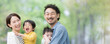 逆光の新緑の公園で遊ぶ仲良しで笑顔の日本人家族　カメラ目線　上半身のクローズアップのバナー