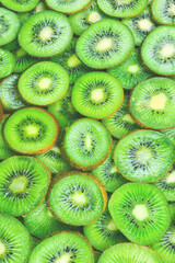 Wall Mural - Top view of heap of sliced kiwi as textured background.