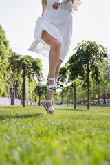 Wall Mural - pretty young woman jumping on green grass