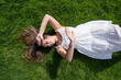 pretty young woman lying on green grass