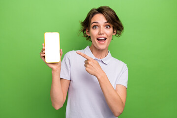 Photo of funky excited lady wear grey t-shirt showing finger apple iphone samsung gadget empty space isolated green color background