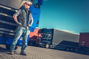 Wall Mural - European Semi Truck Driver Staying Next to His Blue Semi Truck