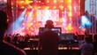 A DJ stands confidently in front of a stage, preparing to entertain the crowd with music.