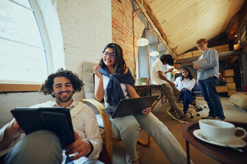 Modern office lifestyle. Well-lit, comfortable co-working area, young people gathering for focused and concentrated work and study. Concept of business and education, co-working space