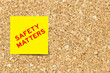 Yellow note paper with word safety matters on cork board background with copy space