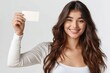 © Preb Creations - A photo of an attractive woman smiling and holding up her white business card against a solid white background, in the style of an Instagram post