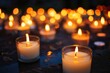 Photo of burning mourning candles on a table against a black background. Lighting candles for bad events, tragedies, in memory, memorial candles, reverence, rest in peace.