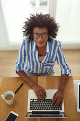 Wall Mural - Portrait, woman and top view with laptop, working and home with coffee, remote work and smile. African employee, typing and glasses for computer, online and electronic or freelancer, pc and digital