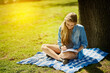 © peopleimages.com - Young woman, happy and notebook for study in nature for test, education and scholarship in countryside. Female student, gen z and paper by tree for learning, reading and smile for brainstorming