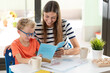 Mother and myopic son enjoy reading a children's book at home