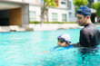 © DG PhotoStock - Father and son swimming together.