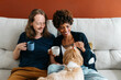 Couple enjoying coffee and bonding with their dog at home