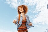 Fototapeta Sport - Cheerful Lady: Smiling Afro-Model with Joyful Expression, Embracing Freedom and Happiness in Natural Sunlight, Walking in a Green City Park