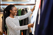 © puhhha - Happy African American Woman Shopping For Clothes In Boutique, Smiling While Choosing Fashion And Retail Concept
