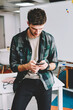 © BullRun - Young pensive smart hipster guy dressed in trendy clothes checking notification on smartphone while chatting in social networks.Male person sending feedback for popular website on modern telephone