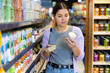 © JackF - Caring young woman visiting pet store in search of tasty and healthy canned wet food for her dog