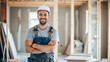 Happy construction worker wearing a hardhat working in a home, house renovation and builder concept