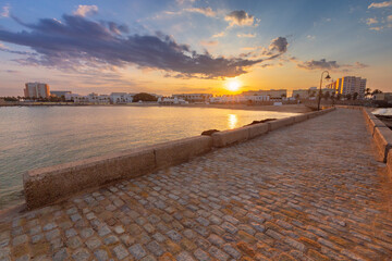 Wall Mural - Breakwater bridge from Fort San Sebastian to the shore at dawn.