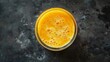 Smoothies mango, orange and carrot in a glass jar. Top view of a freshly prepared drink