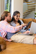 © Wavebreak Media - Biracial woman and Caucasian man, couple, sitting, looking at tablet at home