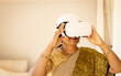 © Wavebreak Media - Indian woman wearing virtual reality headset at home, exploring new tech