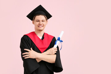 Wall Mural - Happy male graduate with diploma on pink background