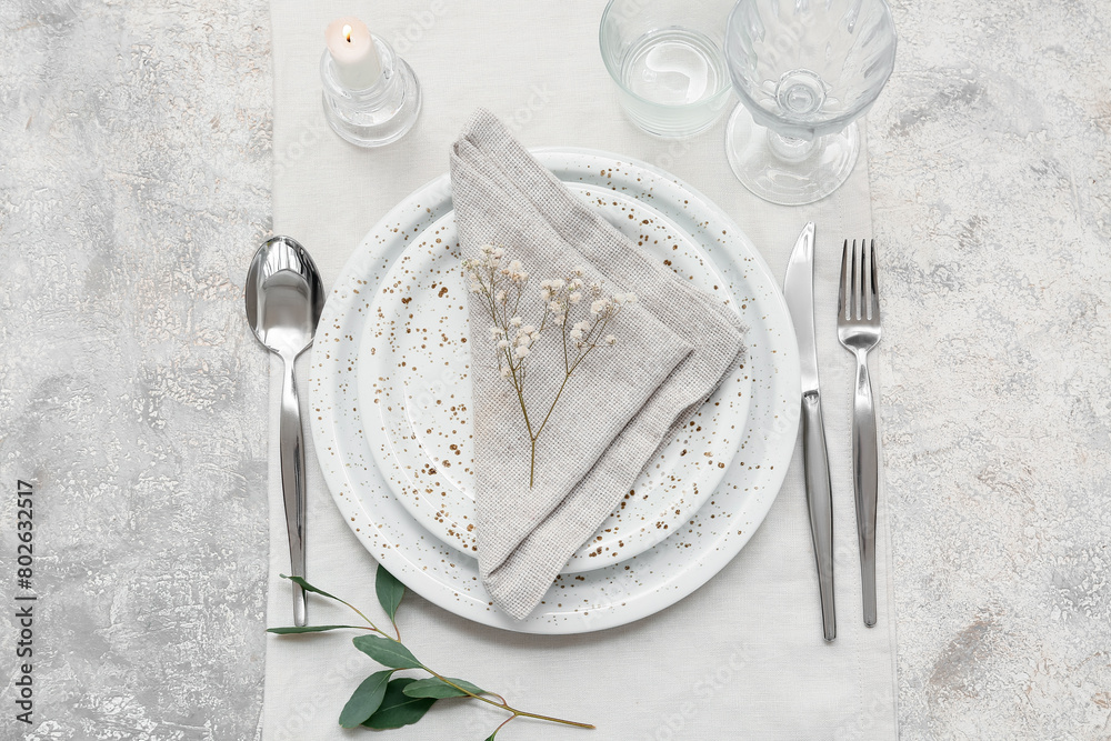 Beautiful table setting with gypsophila flowers and leaves on grey background