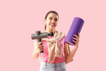 Sticker - Young woman with percussive massager and foam roller on pink background