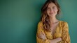 © Salander Studio - portrait of a young woman with a pleasant smile and crossed arms on a green studio background with copyspace