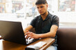 © fx-visual - A man is sitting at a table with a laptop in front of him