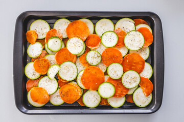 Wall Mural - zucchini and sweet potato slices on oven tray with seasoning